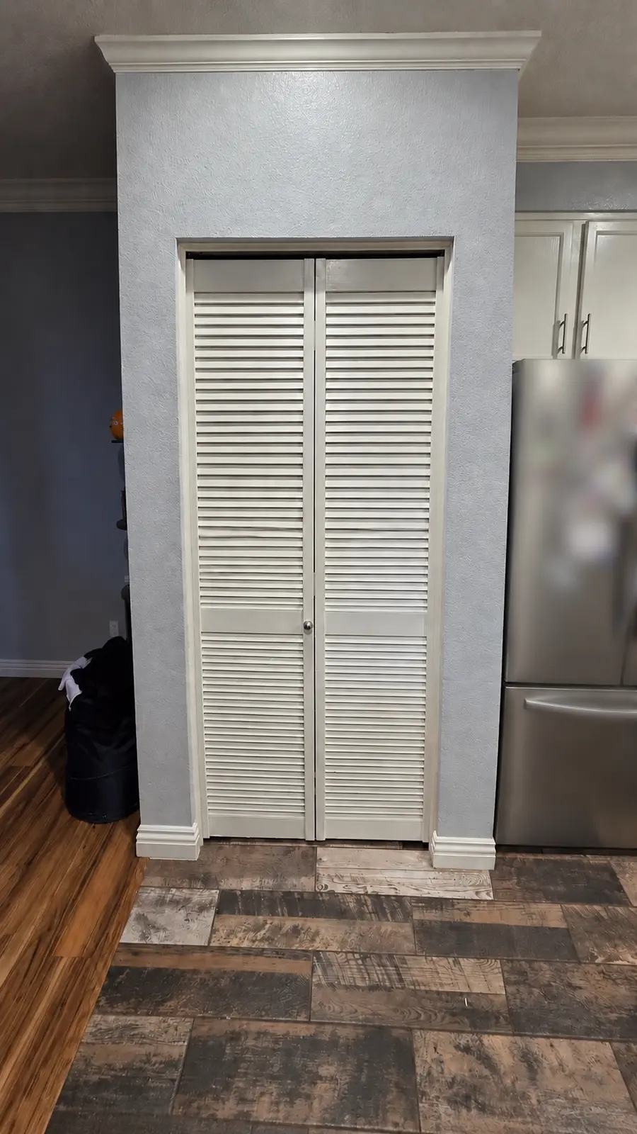 Completed white louvered bi-fold doors installed on a laundry closet